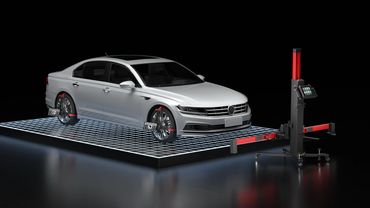 Car undergoing wheel alignment with advanced sensor equipment in a high-tech setup.