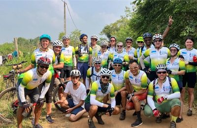 Group of cyclists posing outdoors in biking gear.
