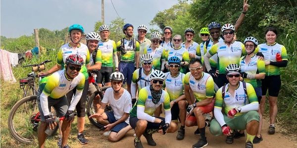 Group of cyclists posing outdoors on a trail.