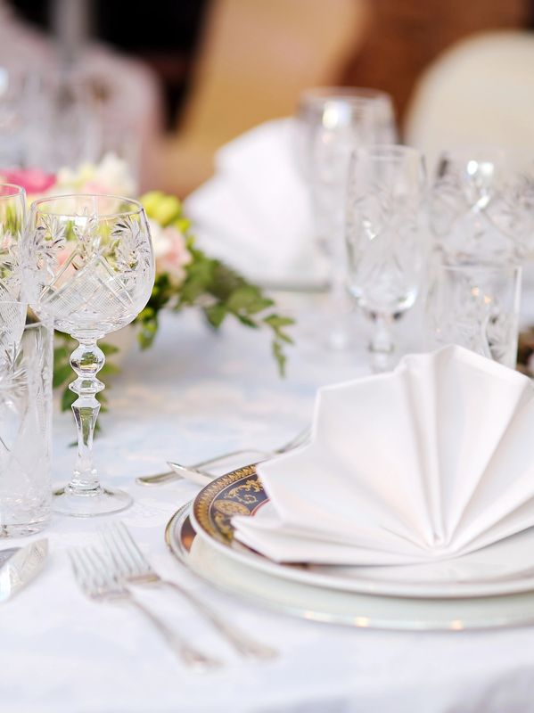 beautiful table setting with crystal glasses, plate and napkin