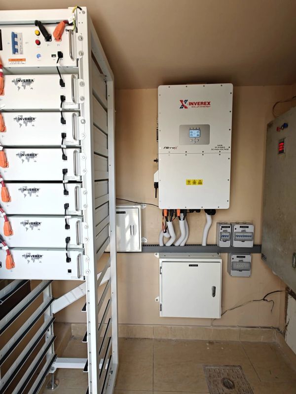 Inverex solar energy system with multiple battery units and control panels installed indoors.