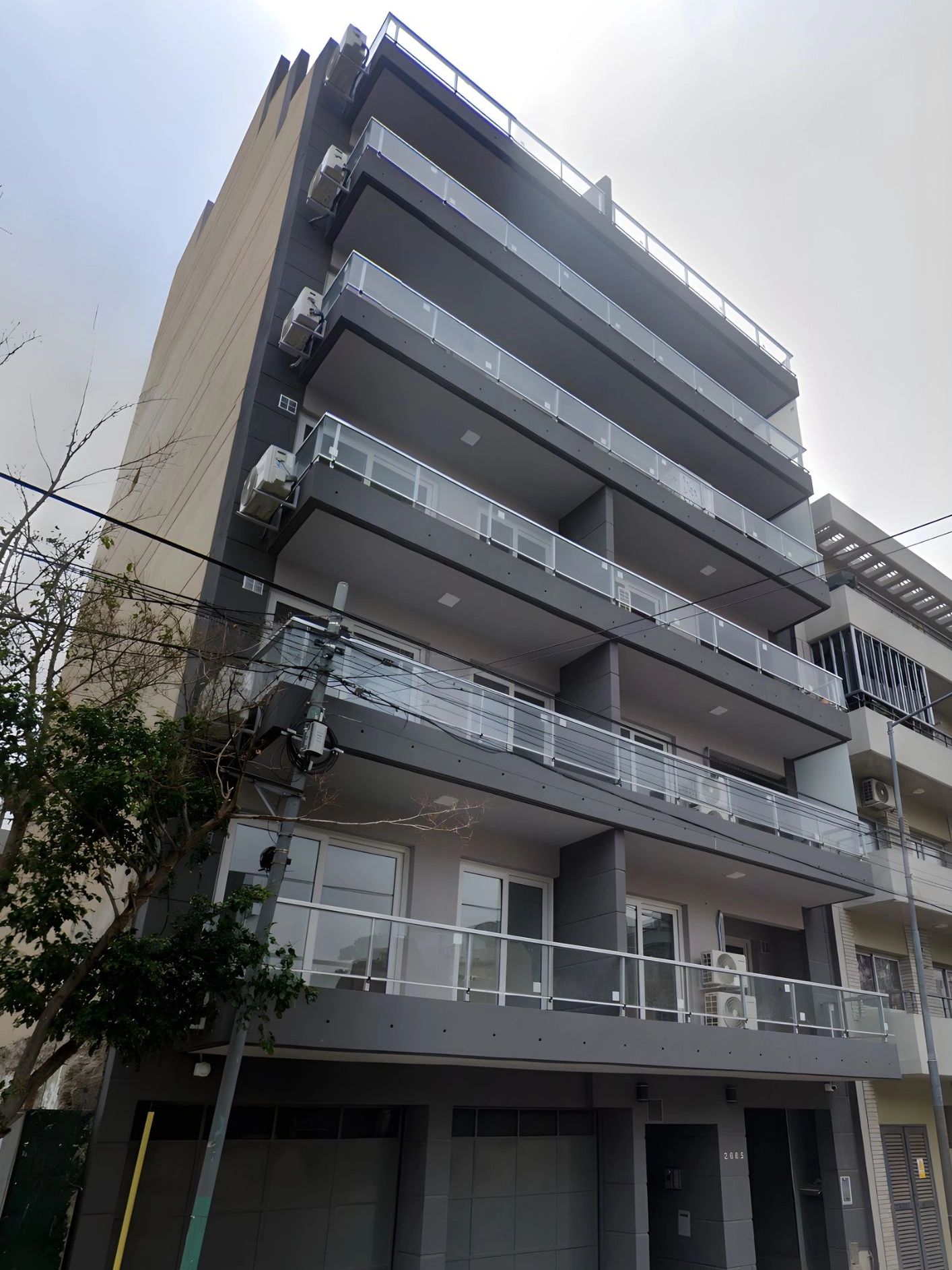 Edificio moderno con balcones y aire acondicionado.