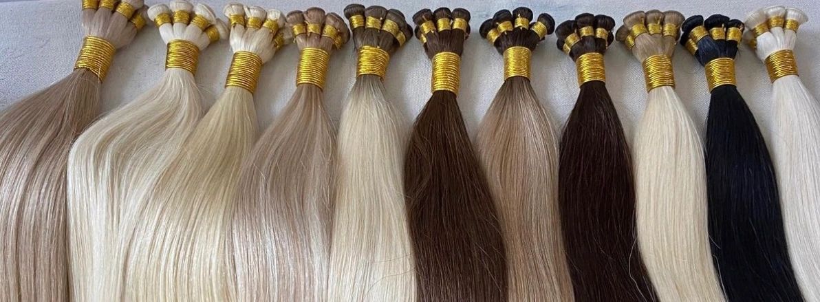 Various hair bundles in different shades tied with golden bands.