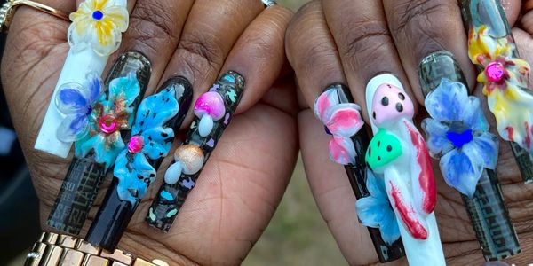 Intricate 3D floral nail art on long black and white nails.