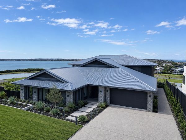 Modern house with a waterfront view and metal roof.