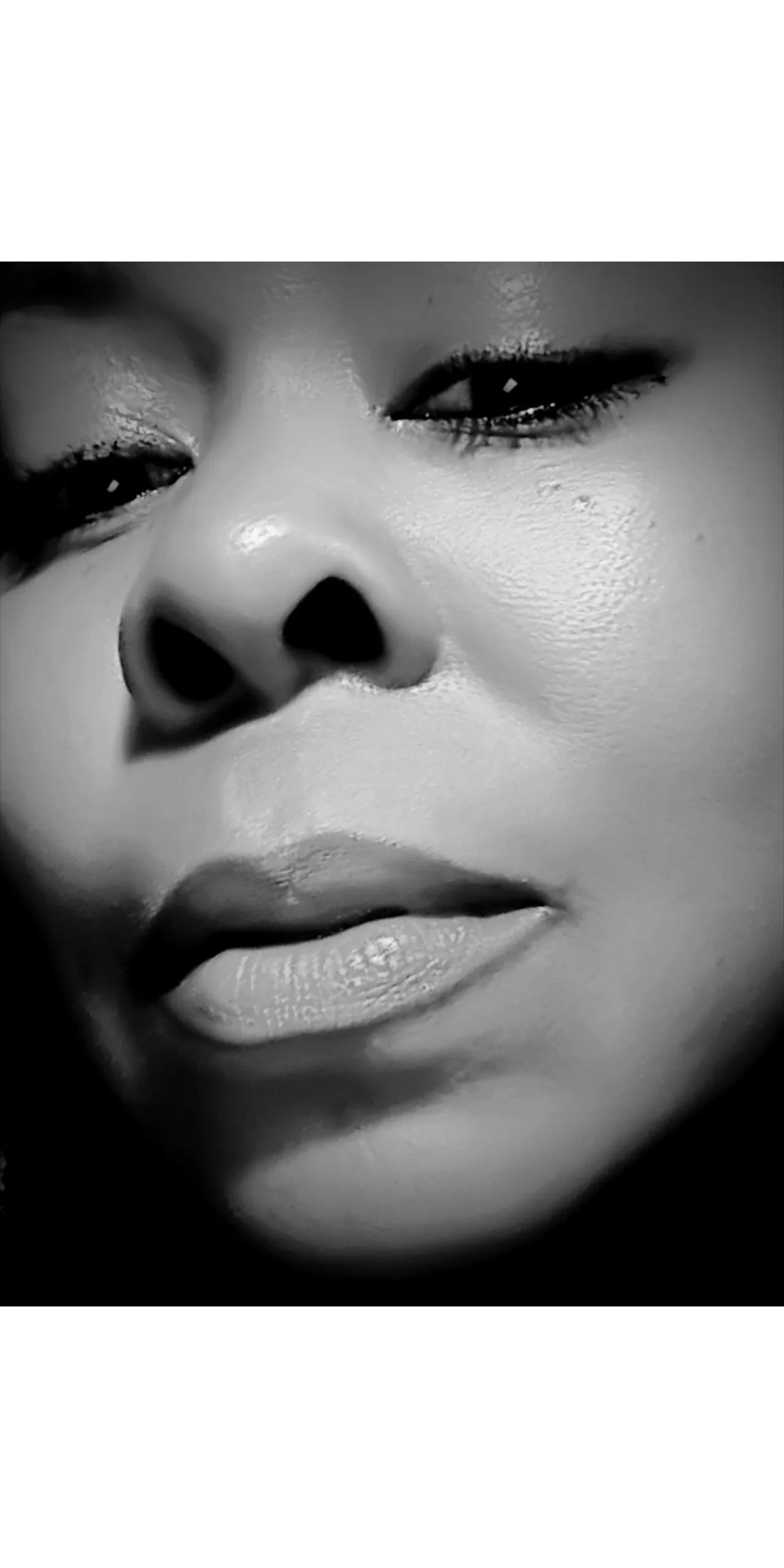 Sheryl Denise in sultry black and white close up headshot photo, black background