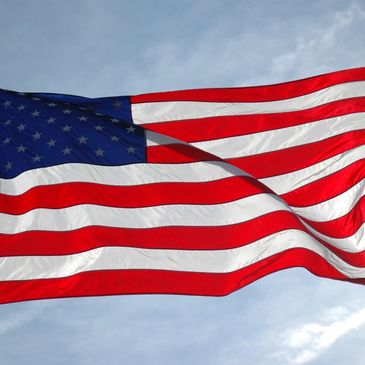 The American flag waving against a clear sky.