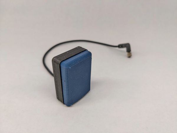 Small blue and black electronic device with a cable and connector.