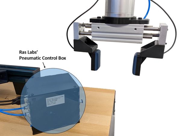 A close-up of Ras Labs' pneumatic control box and robotic gripper on a wooden table.