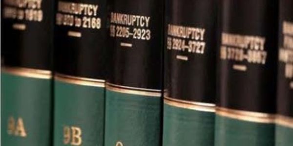 Close-up of bankruptcy law books on a shelf.