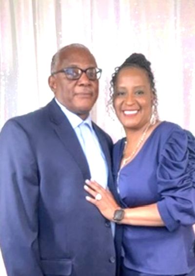 Couple dressed formally, smiling and posing together.
