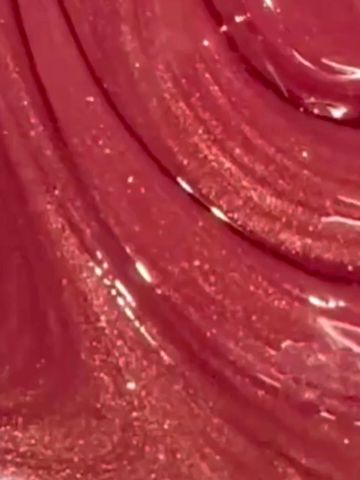 Close-up of glossy, swirled red liquid or gel texture.