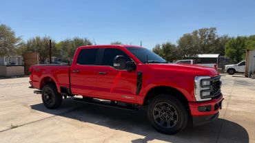 Bright red Ford Super Duty FX4 truck parked outside.