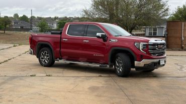 Red GMC Sierra pickup truck parked on a concrete surface.