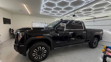 Black GMC Denali HD truck inside a garage.