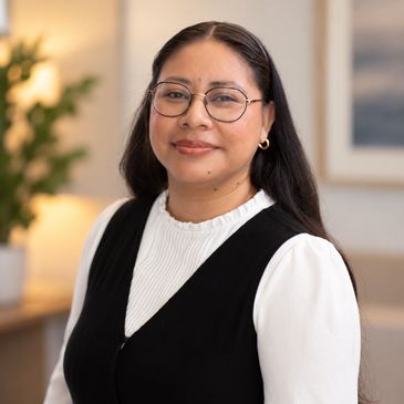 Smiling woman with glasses and long dark hair.