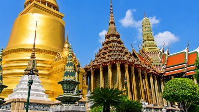 Golden temple complex with ornate spires under a blue sky.