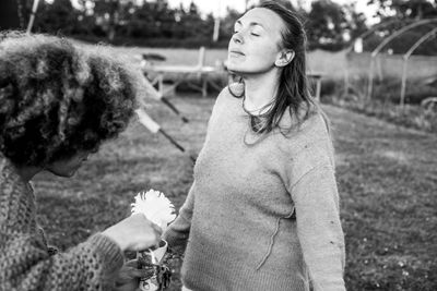 Sasha using swan feathers and a smudging chalice to cleanse a lady.