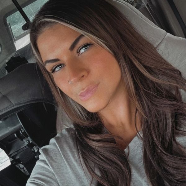 Close-up selfie of a woman with long hair and piercing blue eyes.