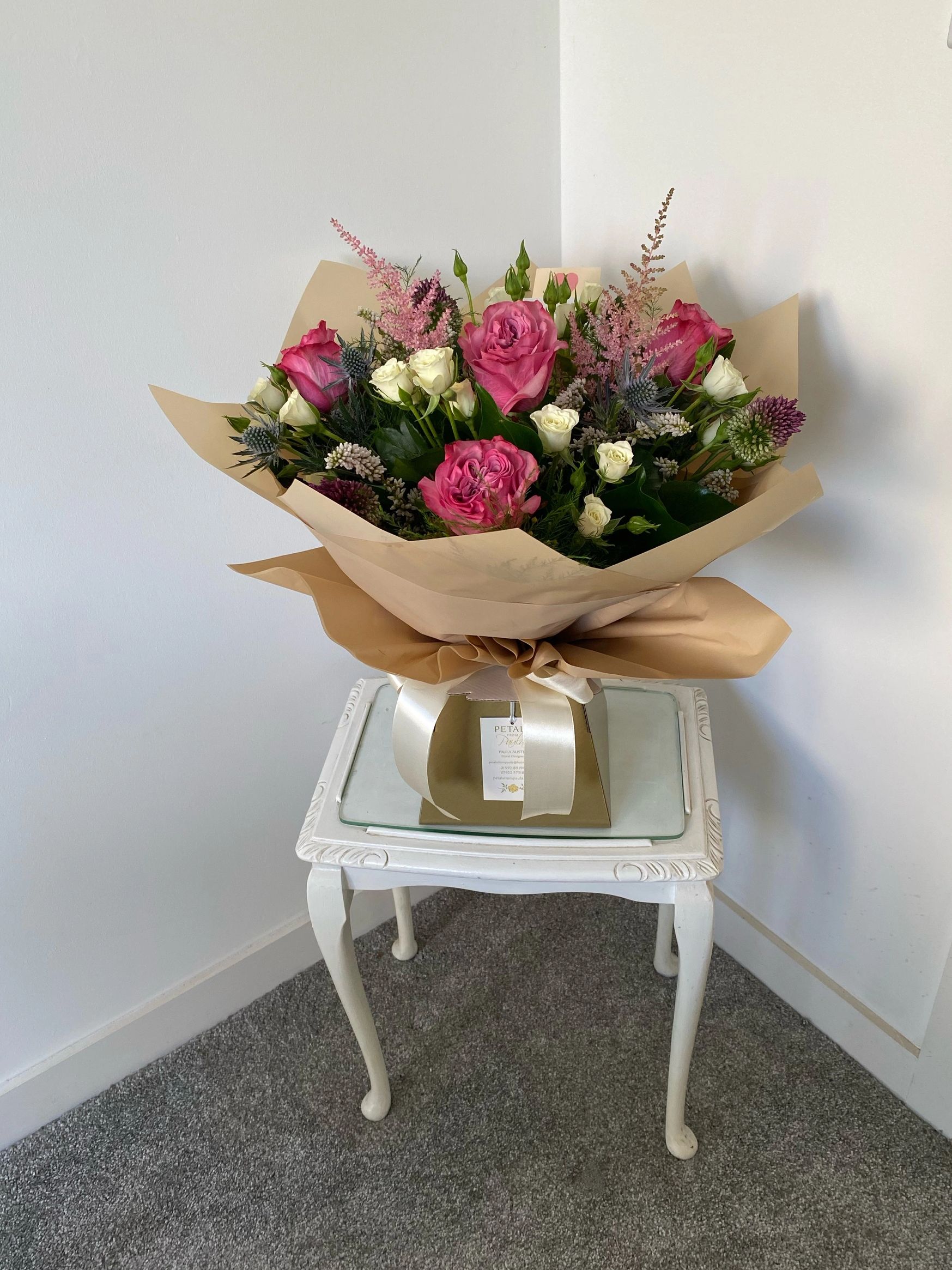 A muted pink winter flower bouquet with an aqua-box.