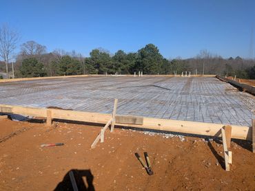 Concrete foundation with steel rebar grid ready for pouring on a clear day.