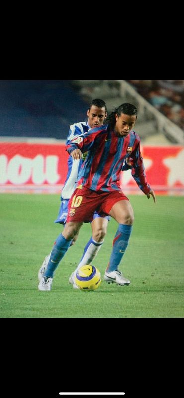 FC Barcelona player dribbling the ball past an opponent in a football match.