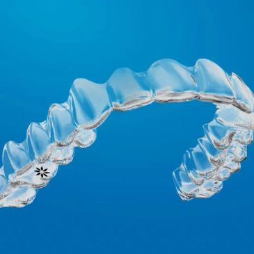 Clear dental aligner against a blue background.
