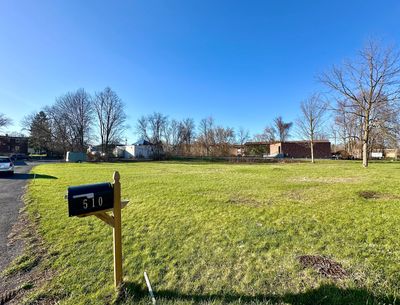 Picture of land at 510 S. Bay Rd, N. Syracuse, NY, from road showing the lot with mailbox in view.