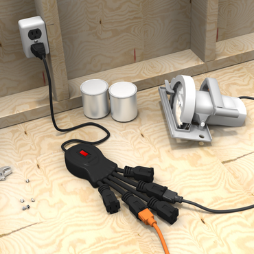 Power strip with multiple plugs on a wooden workbench with tools and paint cans.