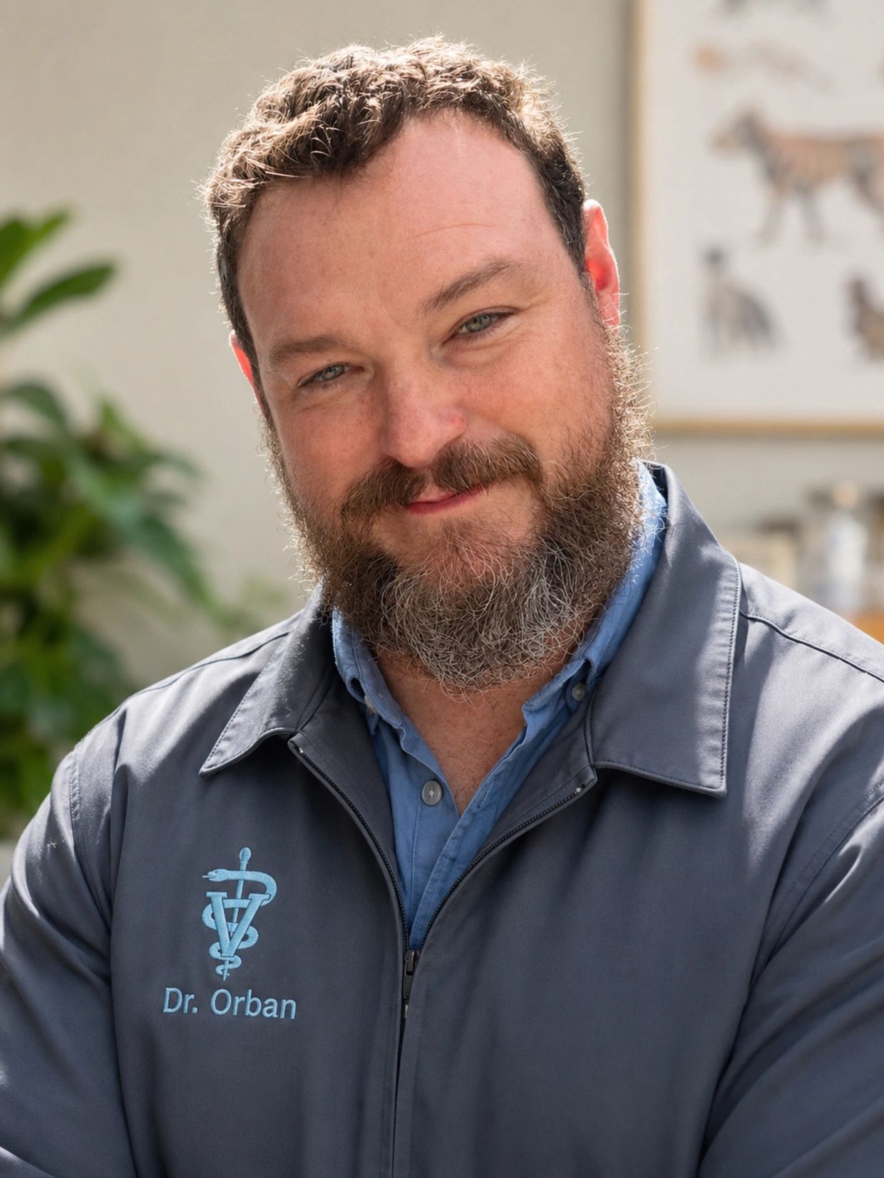Smiling man with beard in veterinary jacket.