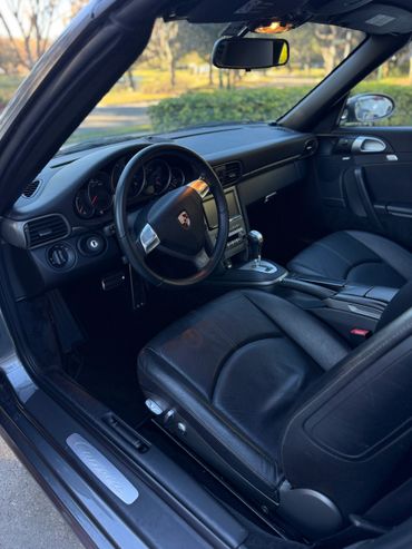 Interior of a Porsche Carrera with black leather seats and a sleek dashboard.