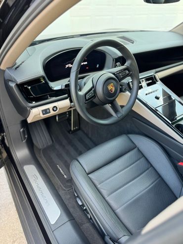 Luxurious interior of a Porsche Panamera with leather seats and advanced dashboard.