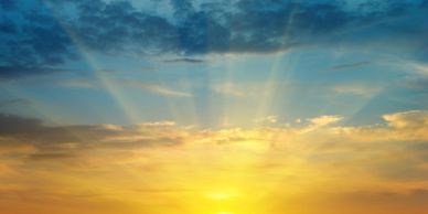 Sun rays breaking through clouds during sunset.