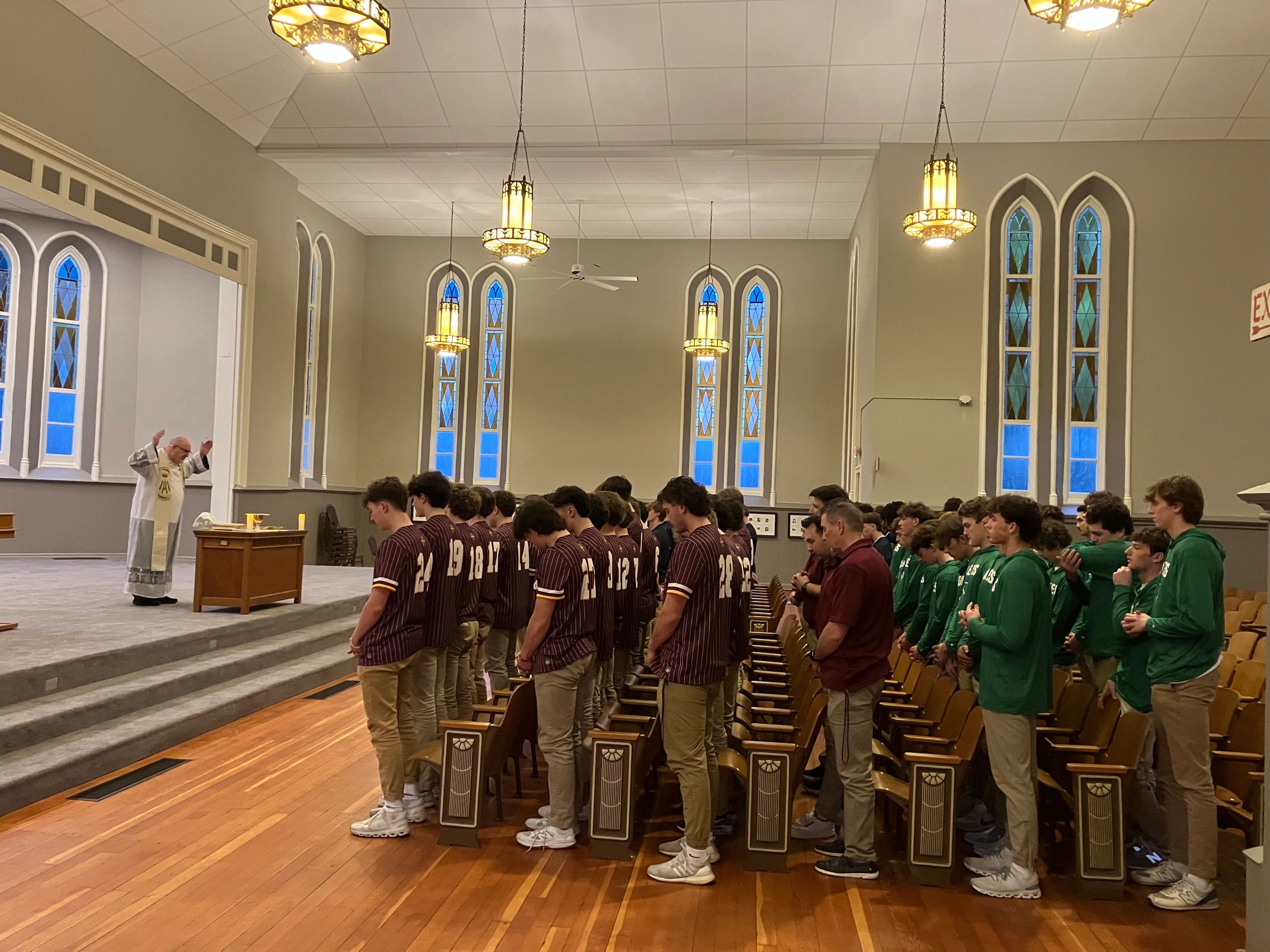 A group of young men praying in a church.