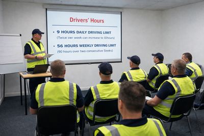 Instructor teaching drivers about daily and weekly driving hour limits.