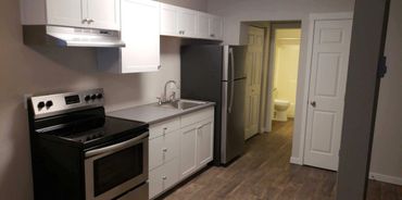 Modern kitchen with stainless steel appliances and white cabinets.