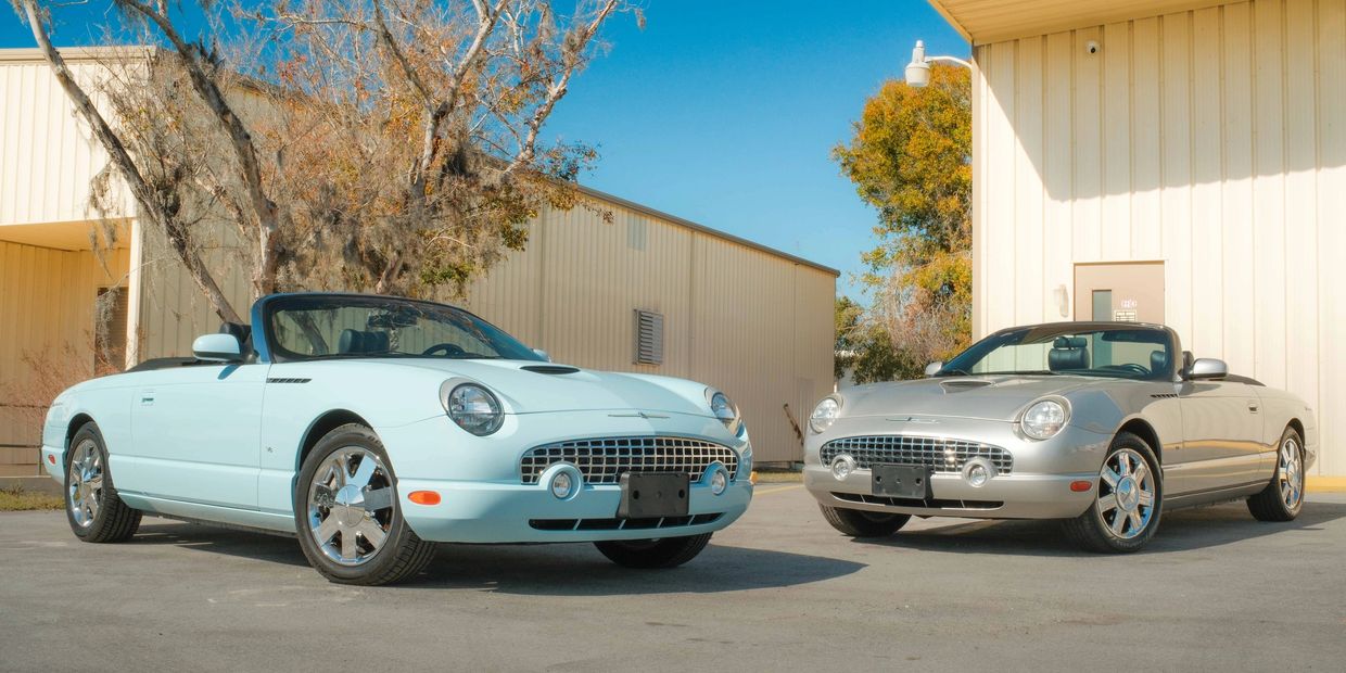 Two vintage convertibles parked outdoors near beige buildings under a clear blue sky.