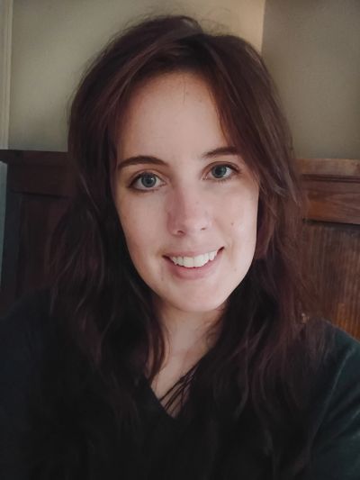 Smiling woman with brown hair and blue eyes.