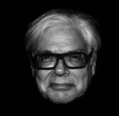 Black and white portrait of an older man with glasses and white hair.
