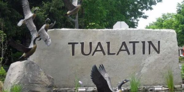 Stone sign with 'Tualatin' and flying birds around it.
