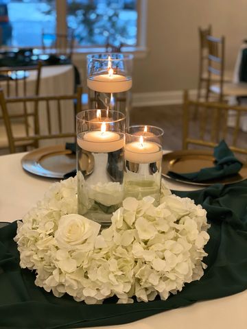 Trio Cylinder vases on a bed of flowers with floating candles