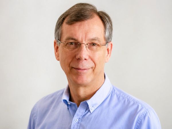 Middle-aged man with glasses in a blue shirt.