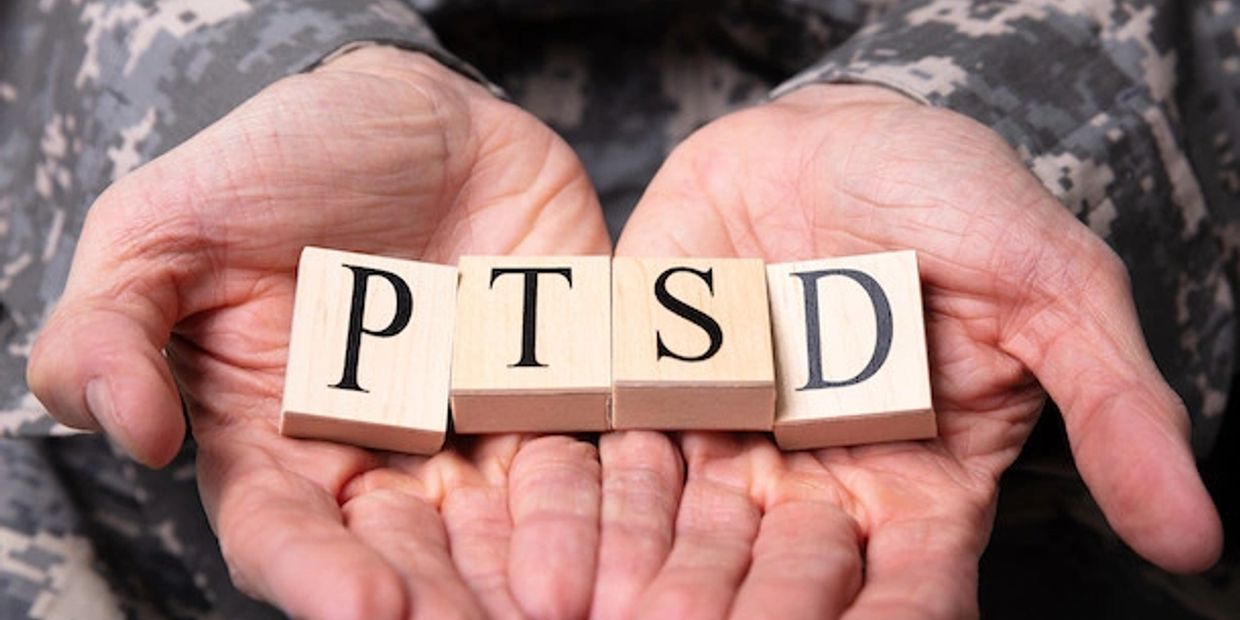 Soldier Holding wood tiles spelling out PTSD