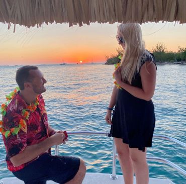 man proposing on tiki boat during a romantic sunset cruise