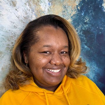 Smiling woman in yellow hoodie.