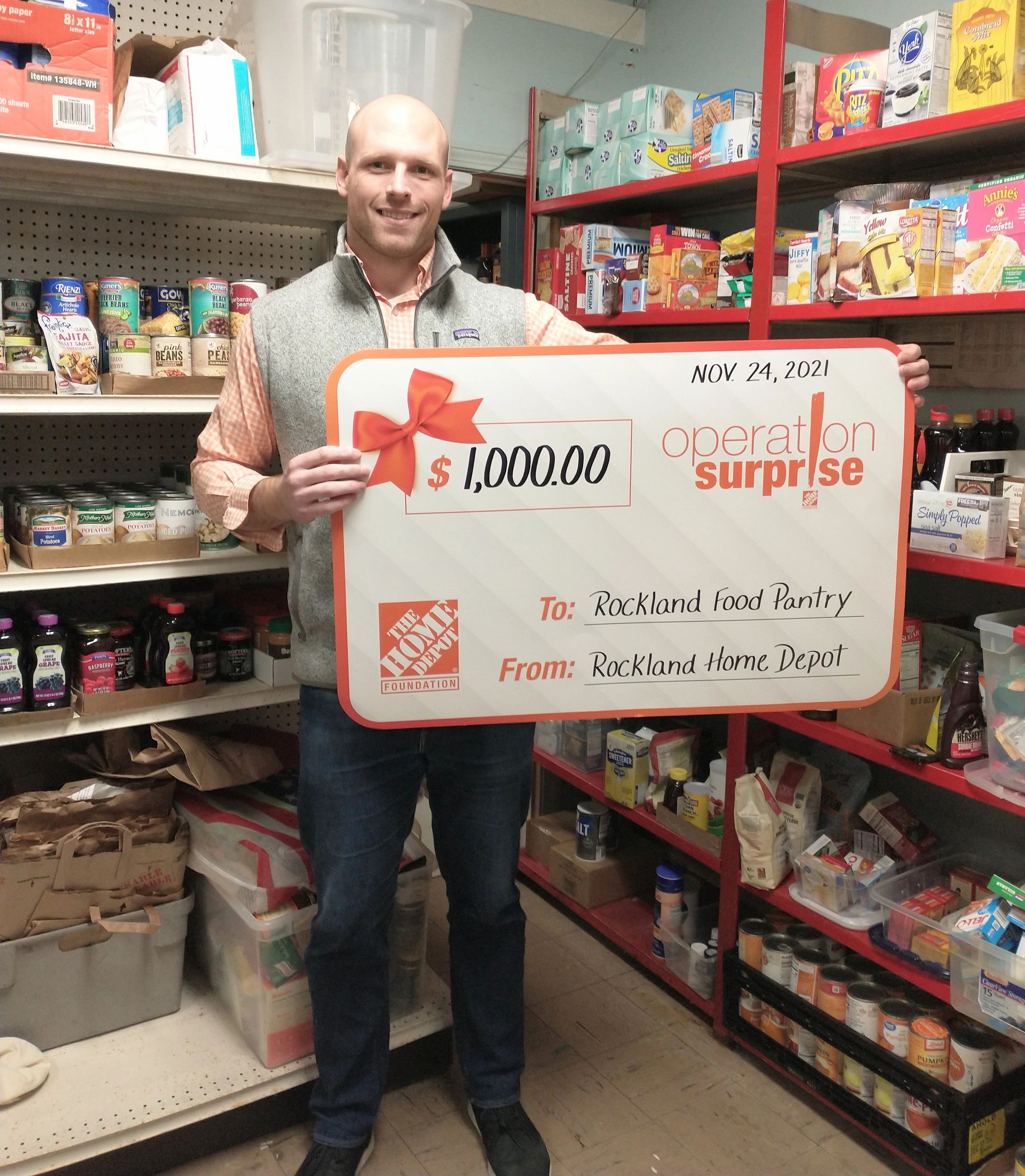 Man holding a $1,000 donation check for Rockland Food Pantry.
