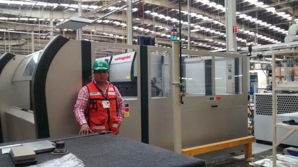 Trabajador en planta industrial junto a maquinaria.