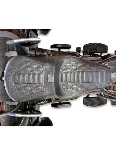 Top view of a black leather motorcycle seat with diamond stitching.