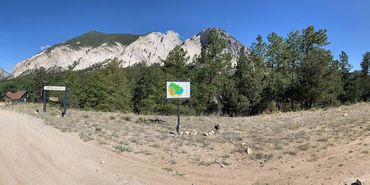 Street view to Aqua, driveway to the left with business sign in front Chalk Cliffs in the background