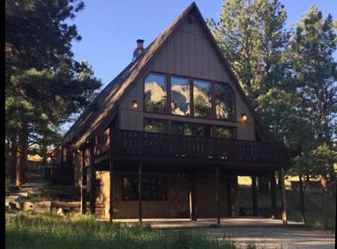 A-frame cabin with Chalk Cliffs reflection in the windows reflection